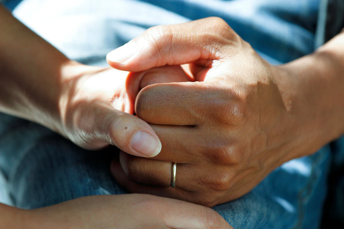 Two people holding hands in support